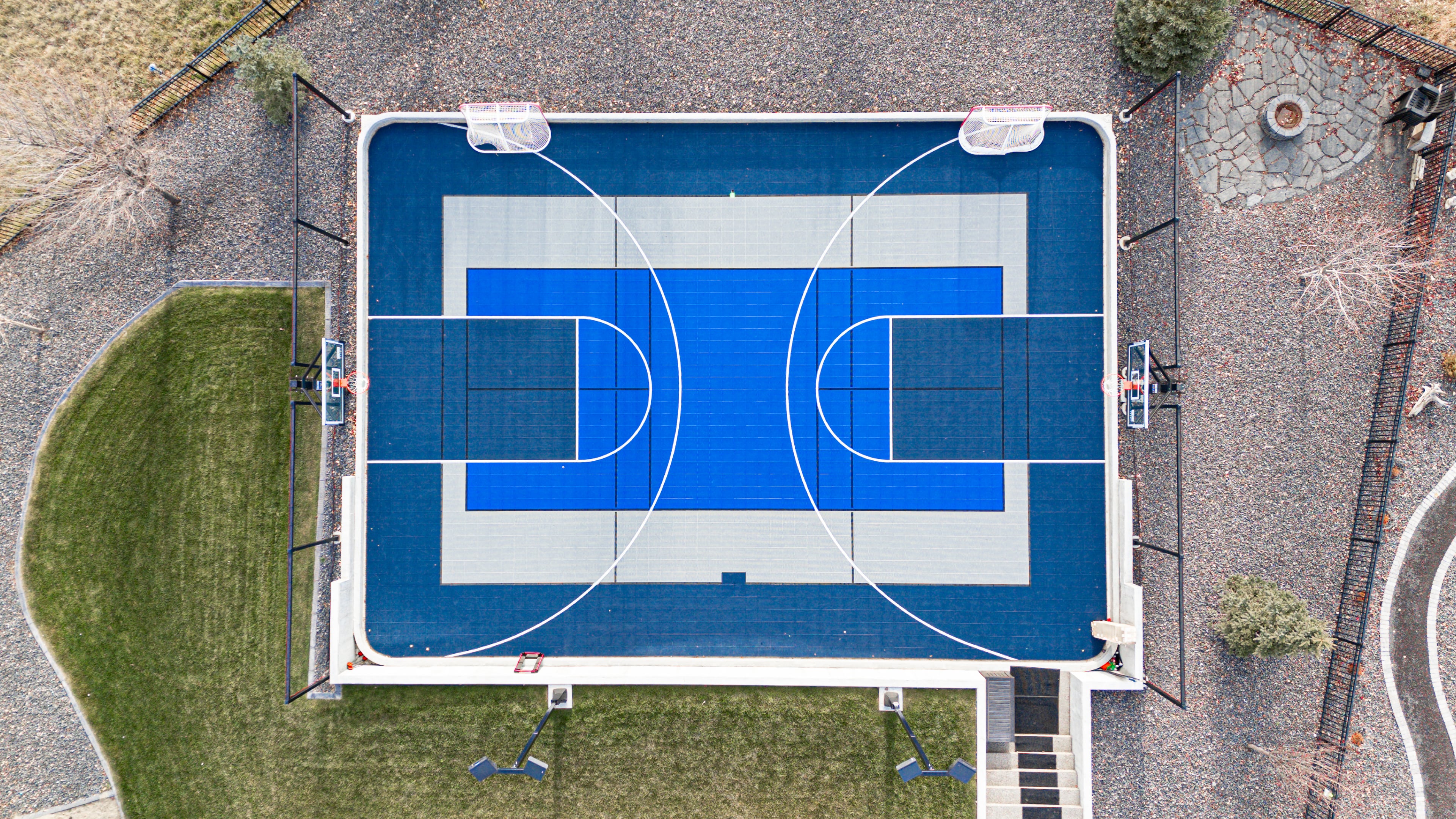 Backyard multi-sport court with basketball and hockey markings in Calgary